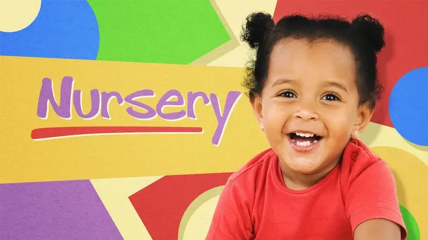 A little girl is smiling in front of a sign that says nursery.