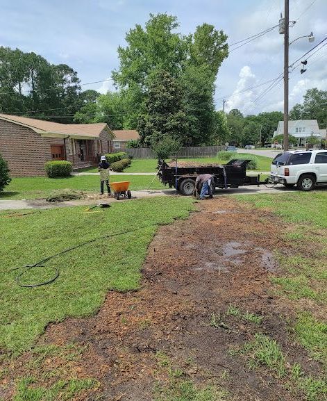A dump truck is parked in a grassy yard next to a house.