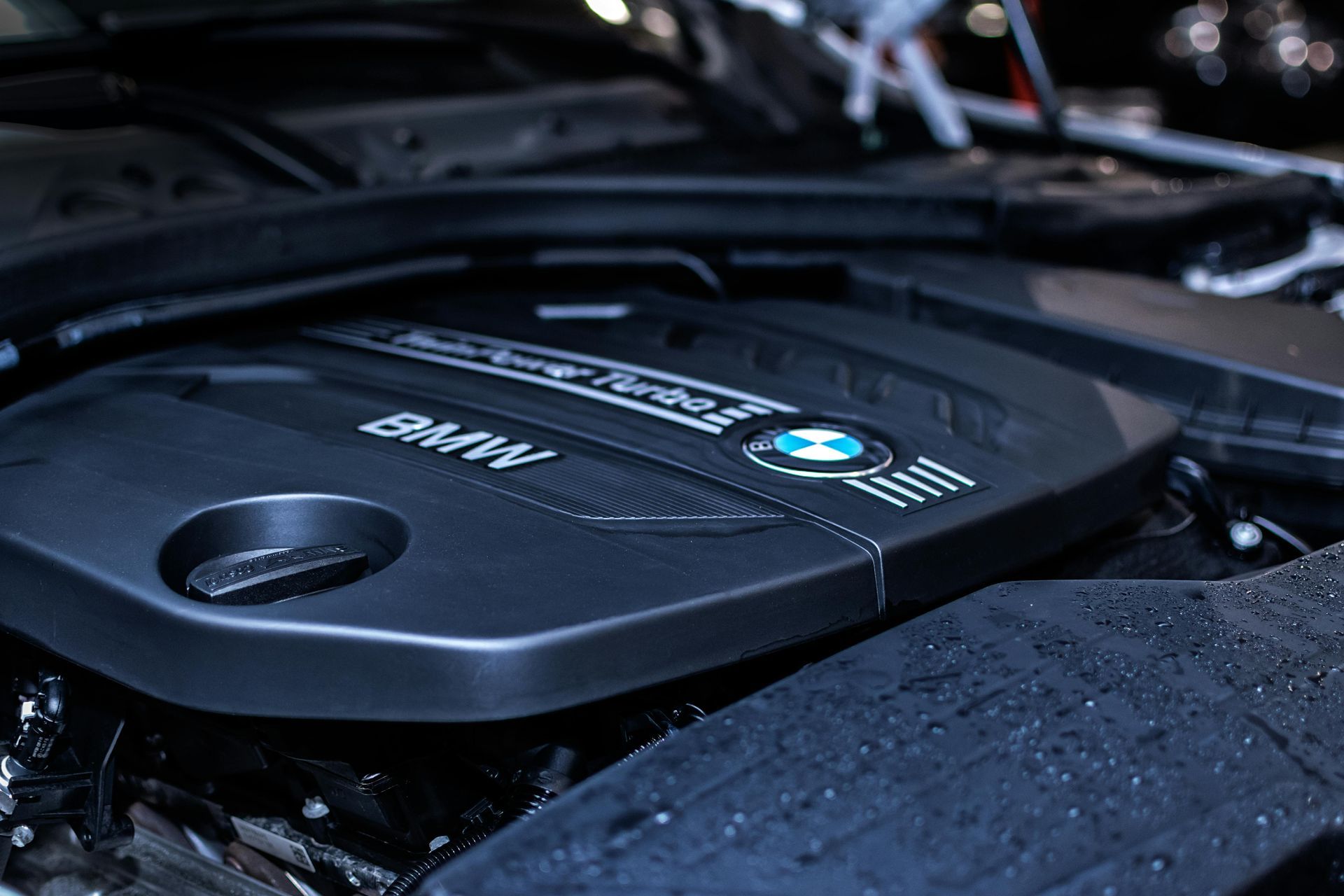 A close-up of a BMW TwinPower Turbo engine cover inside a car's engine bay.