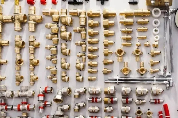 Assortment of brass plumbing fittings displayed on a pegboard wall.