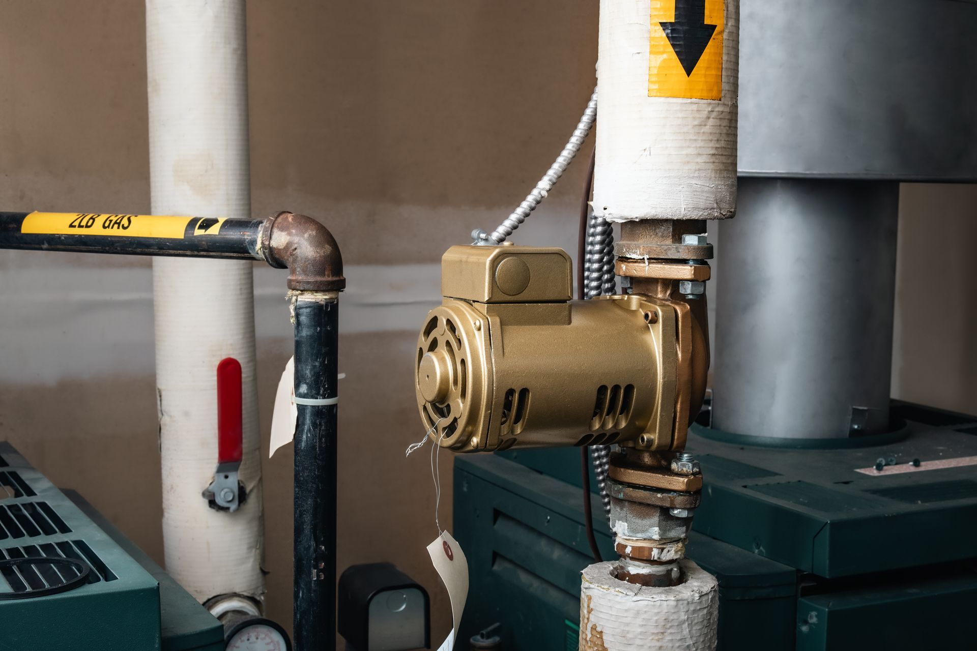 A gold pump attached to pipes in an industrial setting. A gold pump attached to pipes in an industrial setting.