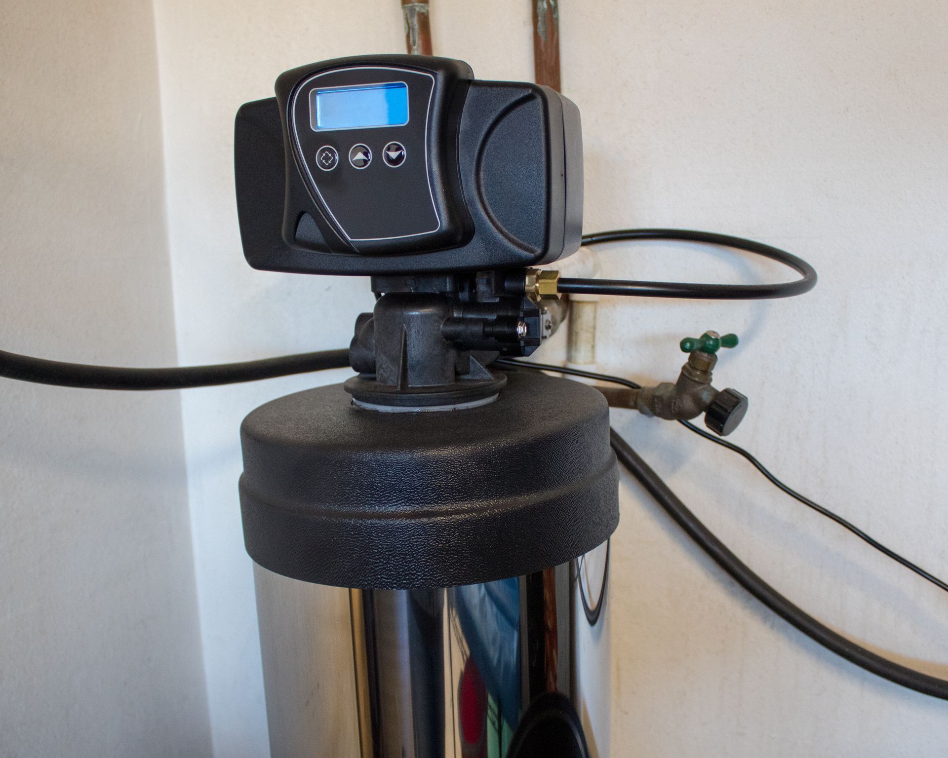 Water softener with digital display on a stainless steel tank.