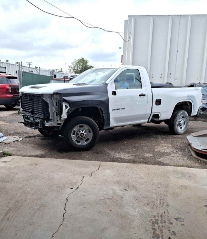A white truck is parked in a parking lot next to a white truck.