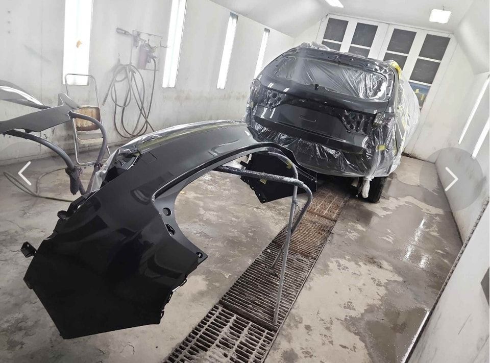 A car is being painted in a paint booth.