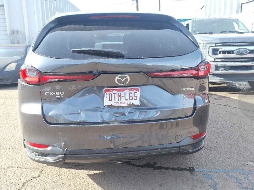 A mazda cx-5 with a damaged rear end is parked in a parking lot.