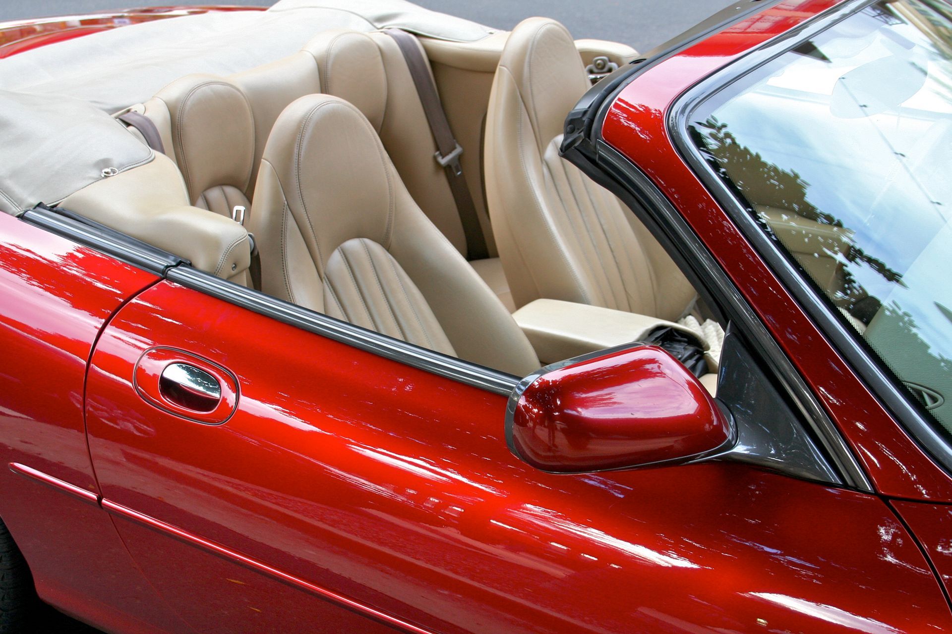 A red convertible with the top down and tan seats