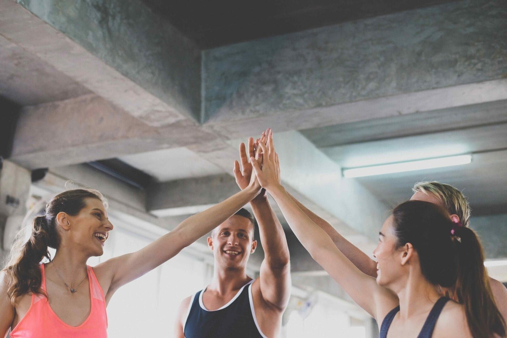 A group of people are giving each other a high five in a gym.