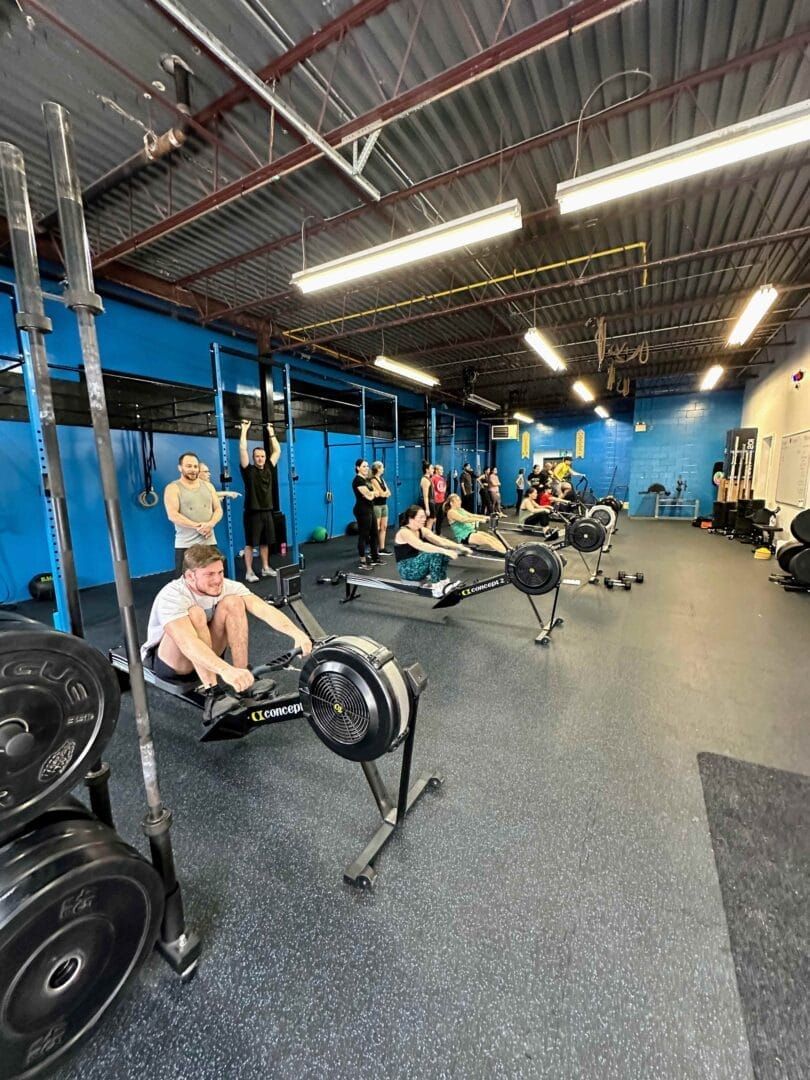 A group of people are using rowing machines in a gym.