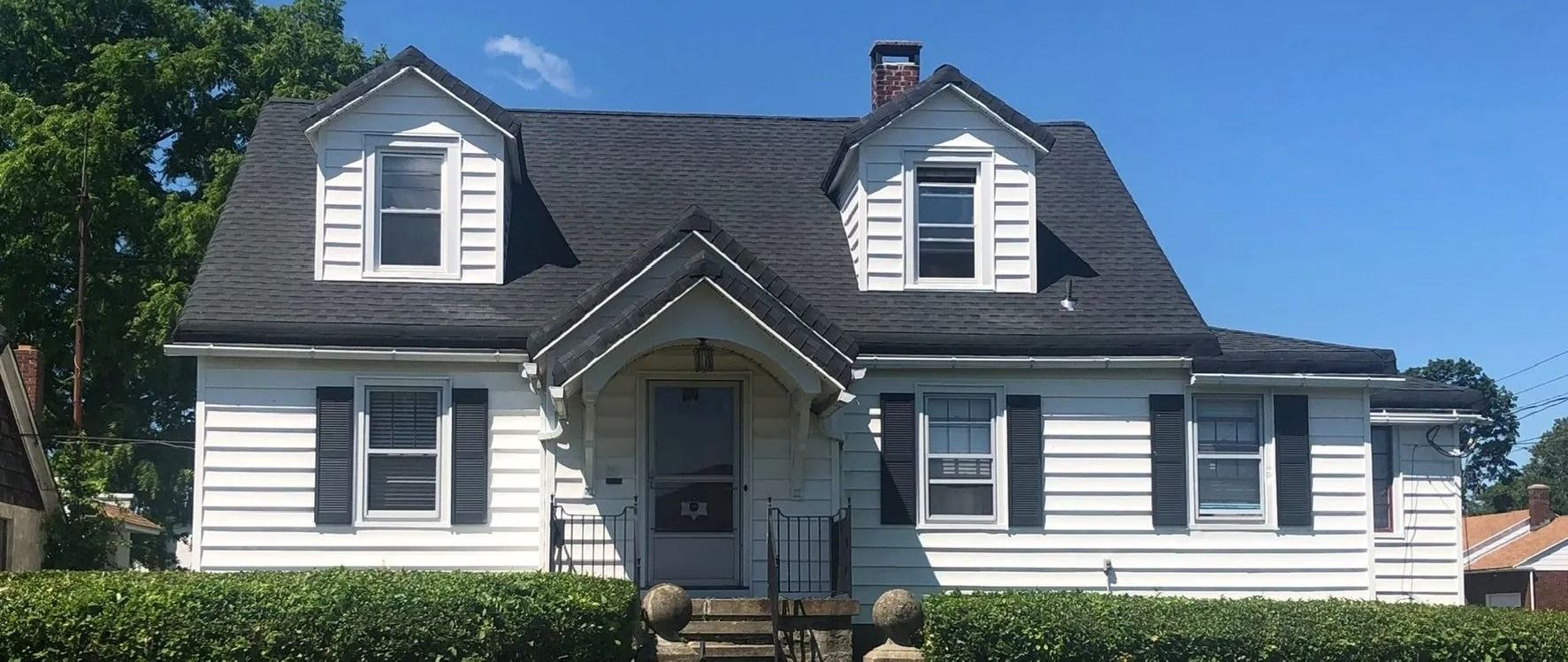 A white house with a black roof and black shutters