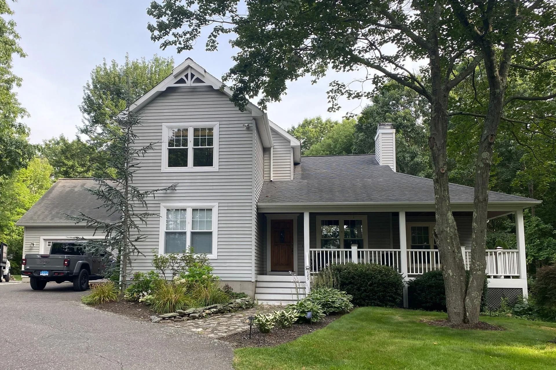 A house with a porch and a truck parked in front of it