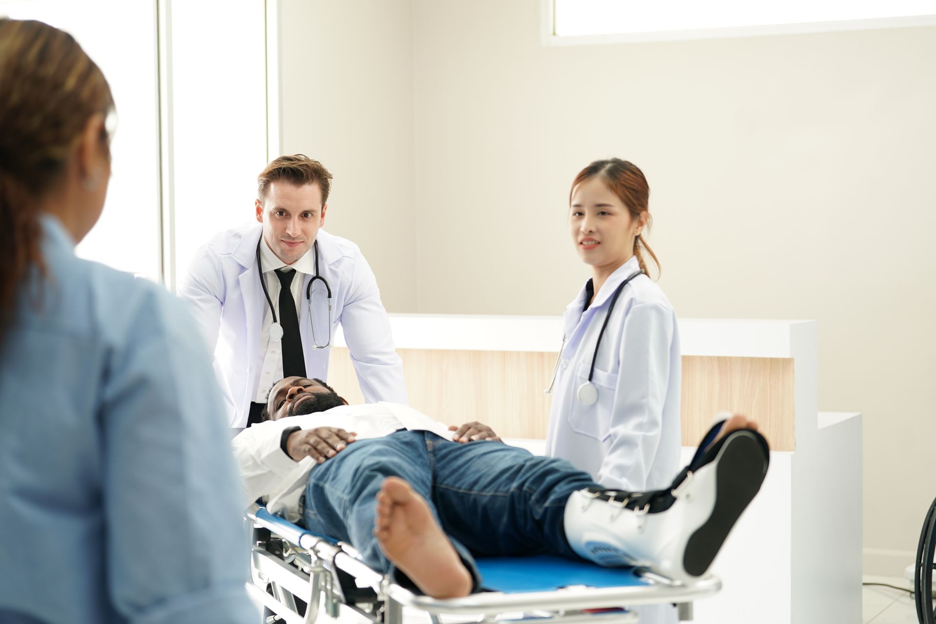 A man is laying on a stretcher in a hospital room.