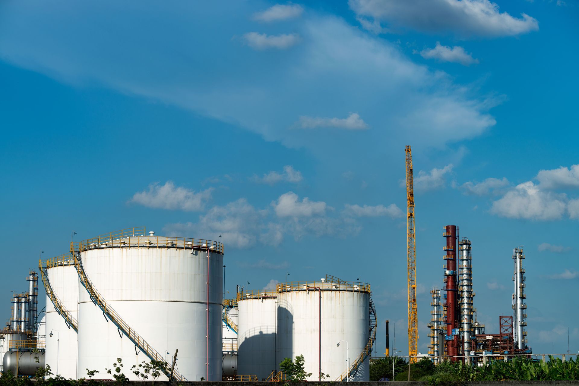 A large oil refinery with a blue sky in the background.
