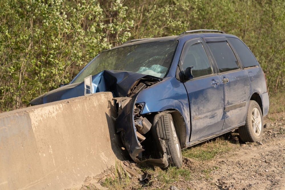 Severely damaged SUV crashed into a concrete barrier on the side of a road