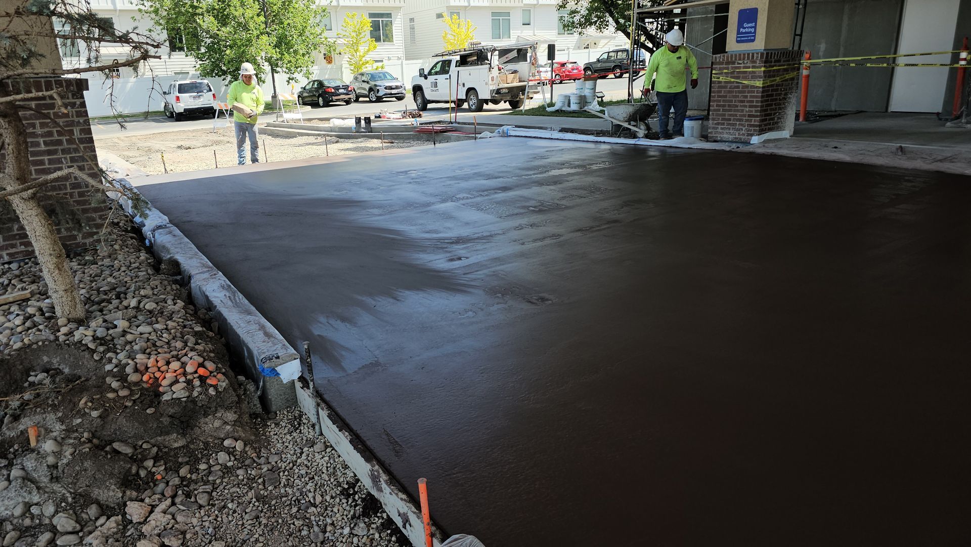 A red car is parked in front of a modern house.