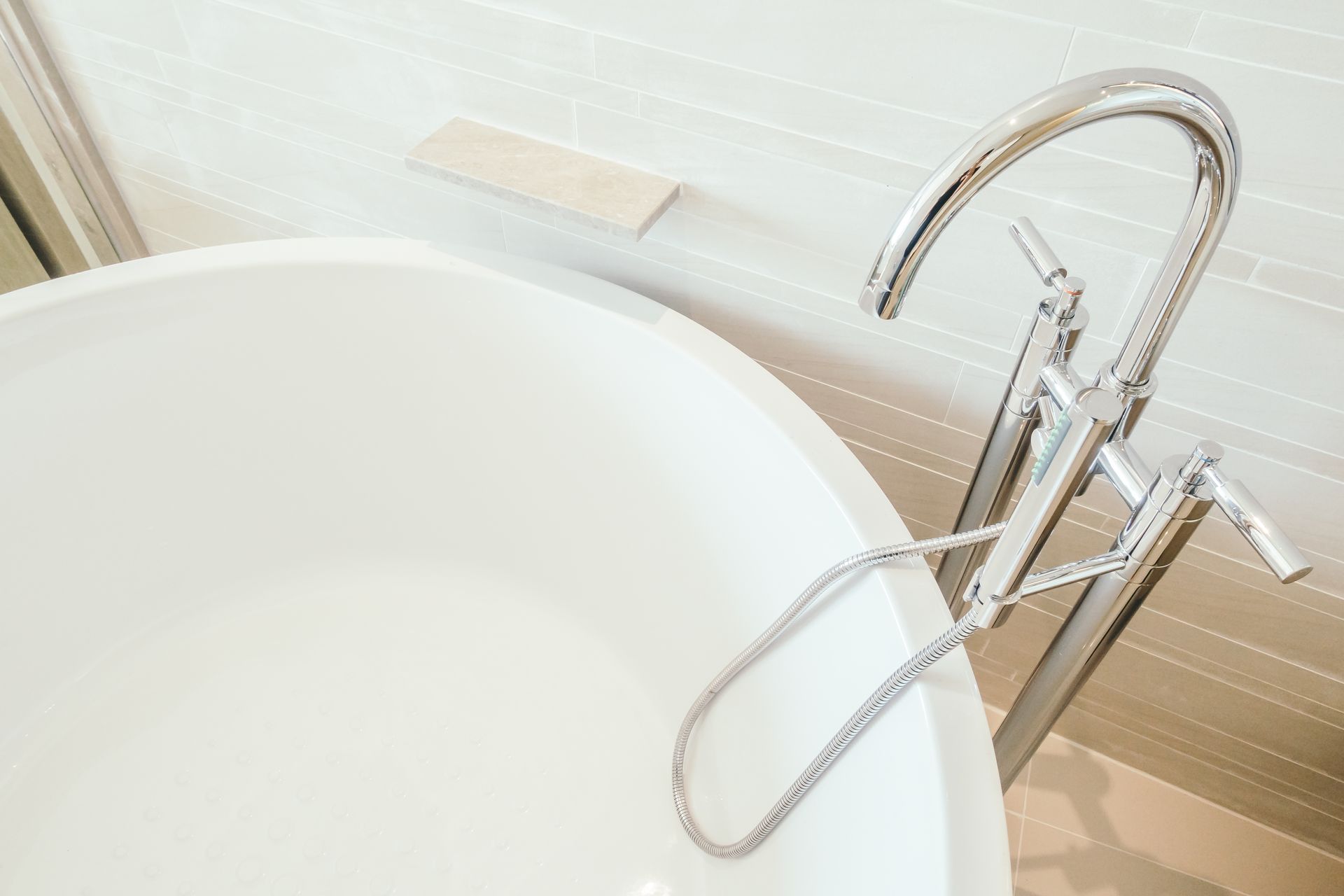 A white bathtub with a chrome faucet in a bathroom.
