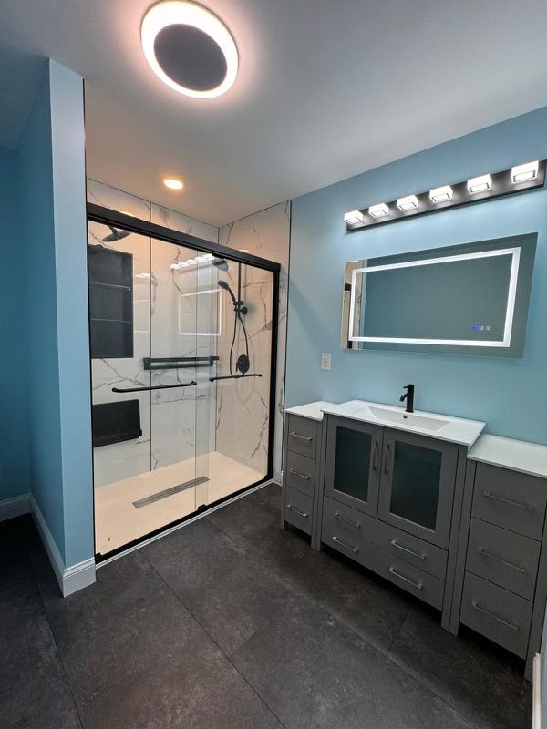 A bathroom with a sliding glass shower door and a sink