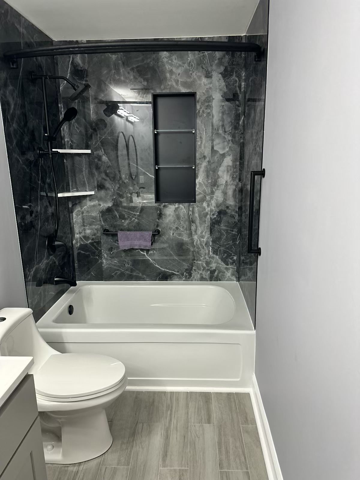 A bathroom with a toilet , tub and shower.