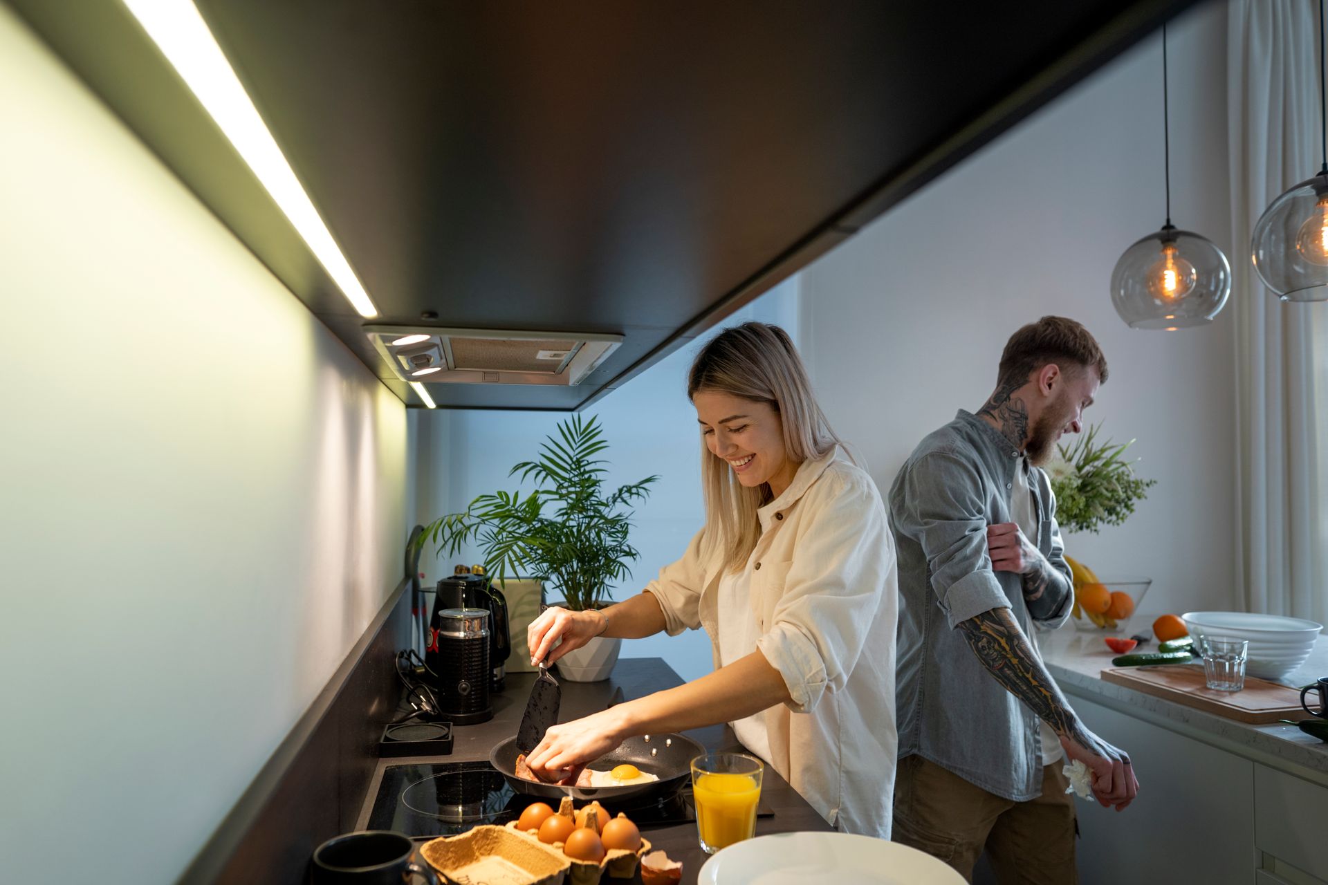 A man and a woman are preparing food in a kitchen.