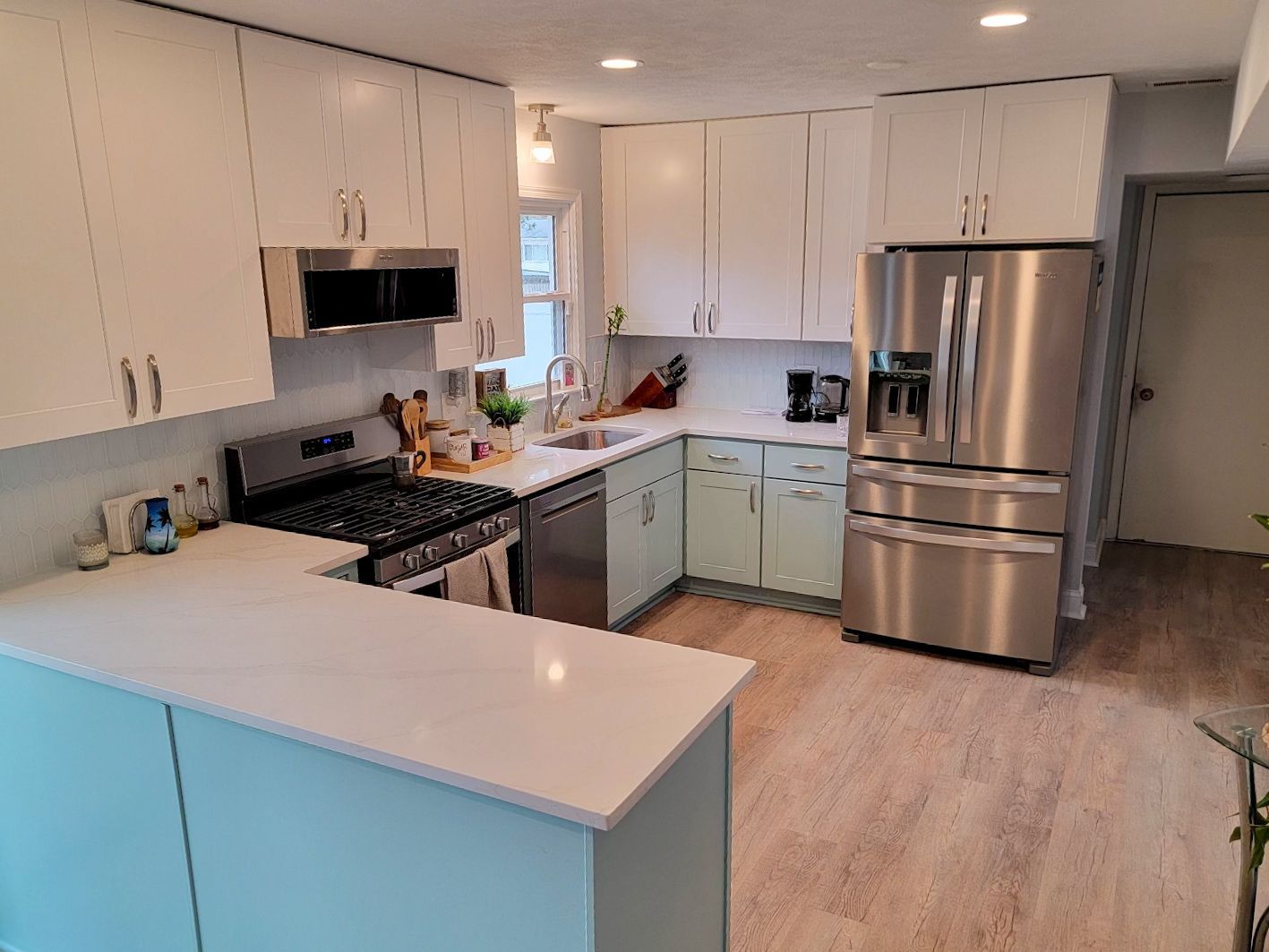 A kitchen with white cabinets and stainless steel appliances.