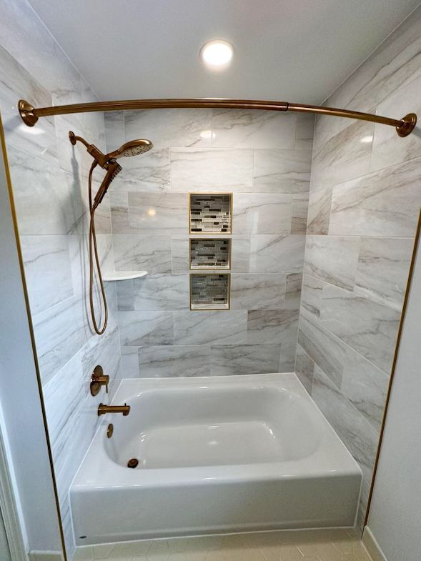 A bathroom with a bathtub and a shower.