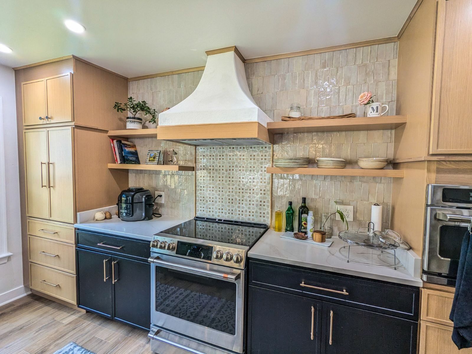 A kitchen with stainless steel appliances and black cabinets.