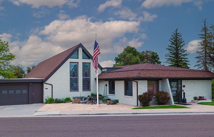 An american flag is flying in front of a brick building