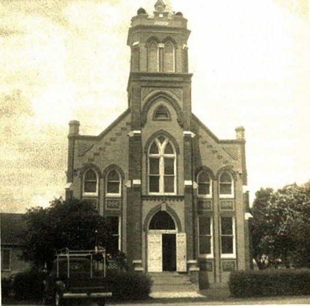 A black and white photo of a church with a clock tower