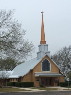 A small church with a steeple and a cross on top