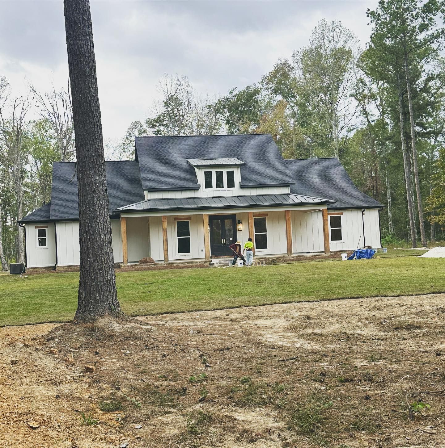 A white house with a black roof and a porch