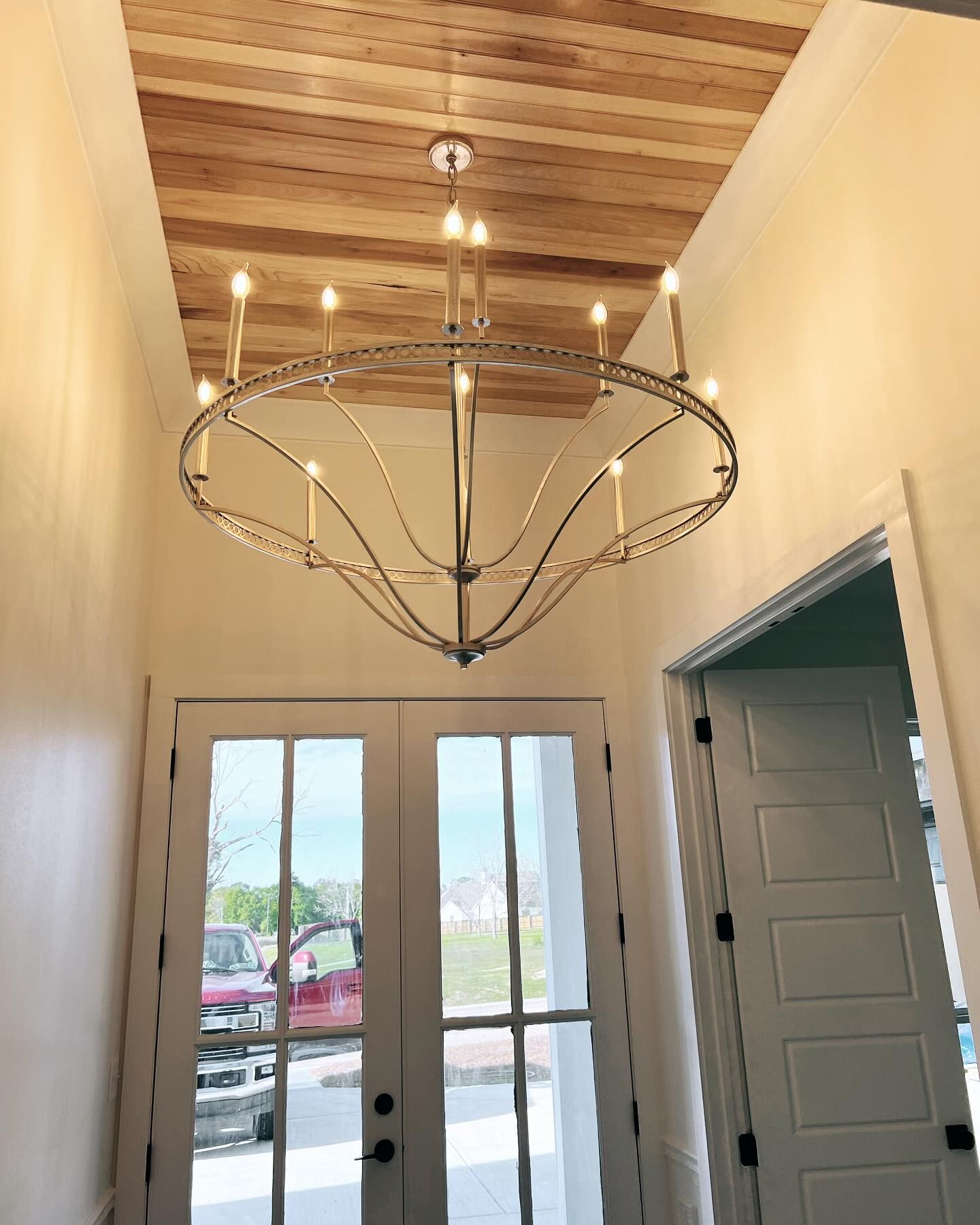 A large chandelier is hanging from the ceiling of a hallway.