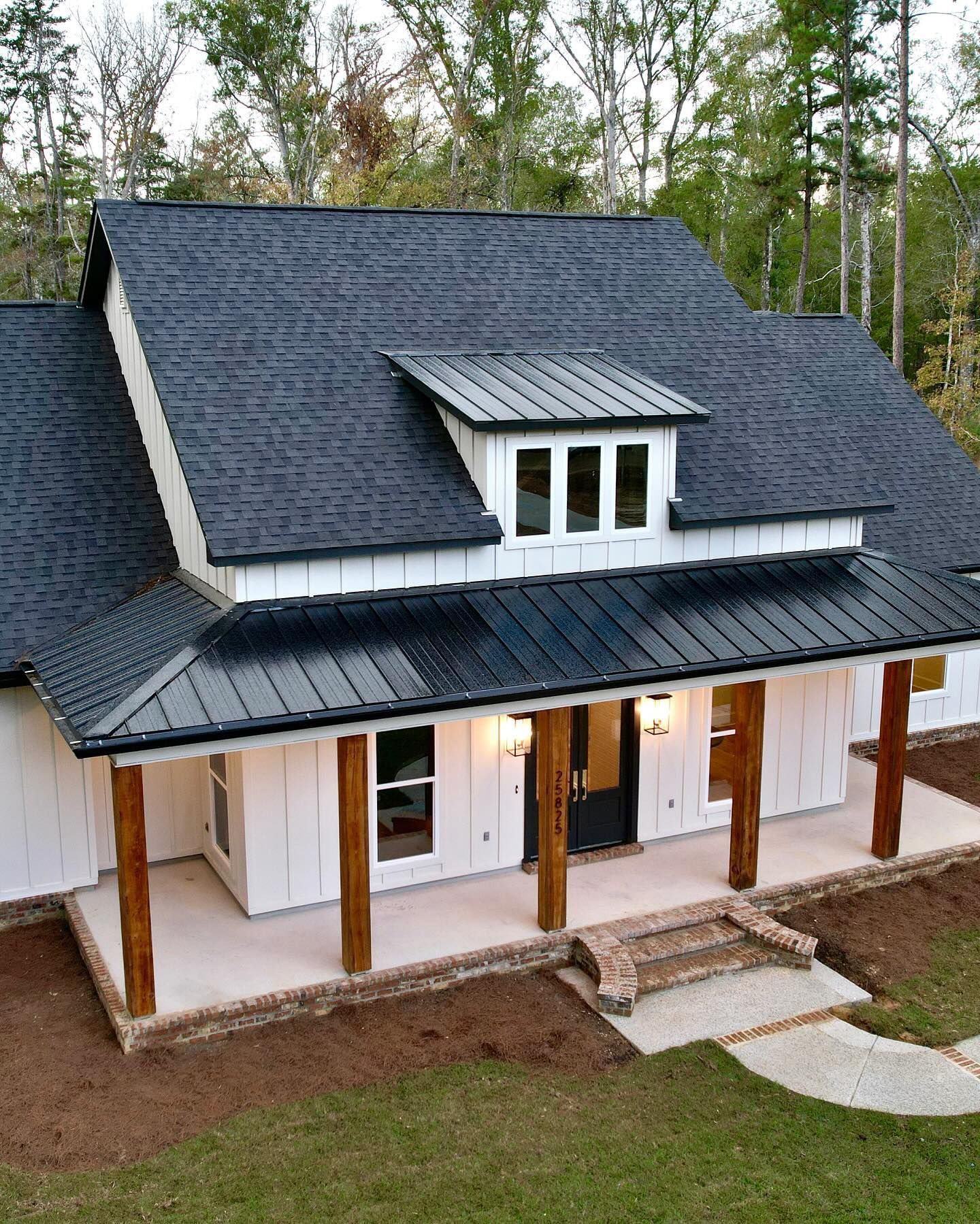 A white house with a black roof and a porch