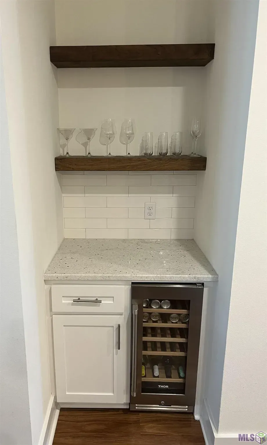 There is a wine cooler in the corner of the room.