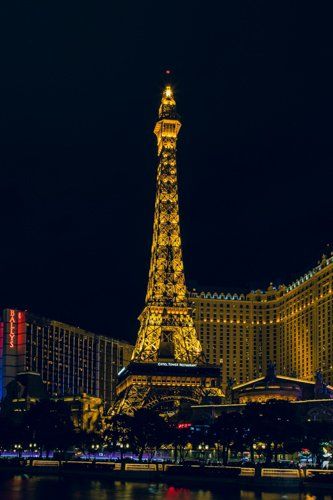 The eiffel tower is lit up at night in las vegas