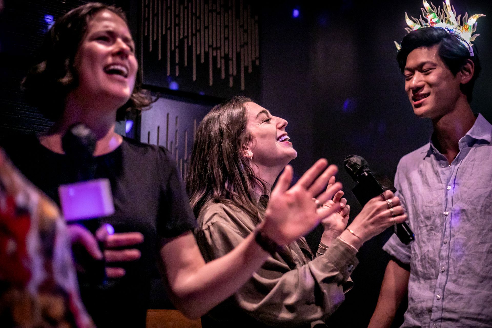 Group of friends having a great time mid song at karaoke
