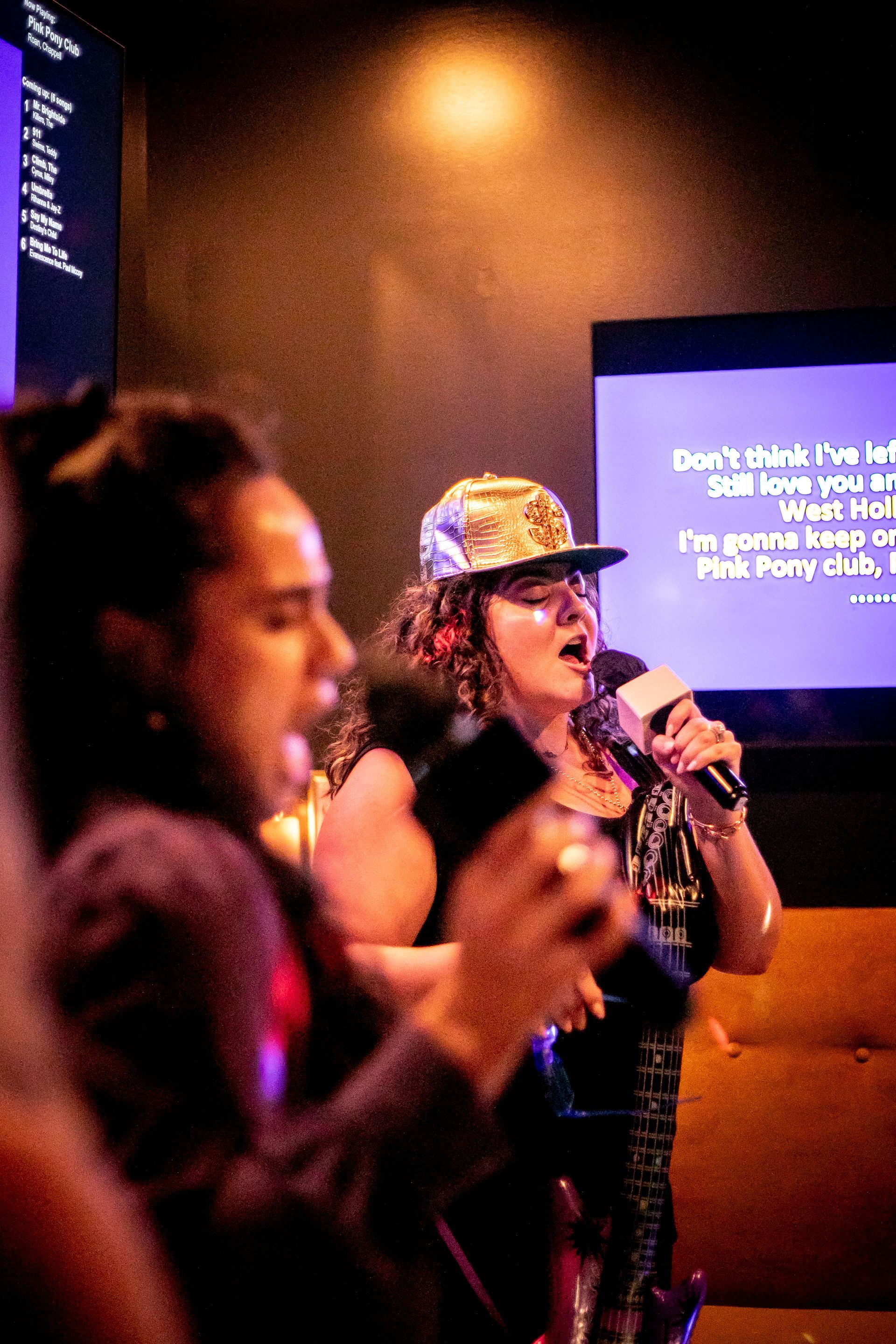Two people singing a duet in a private suite karaoke room