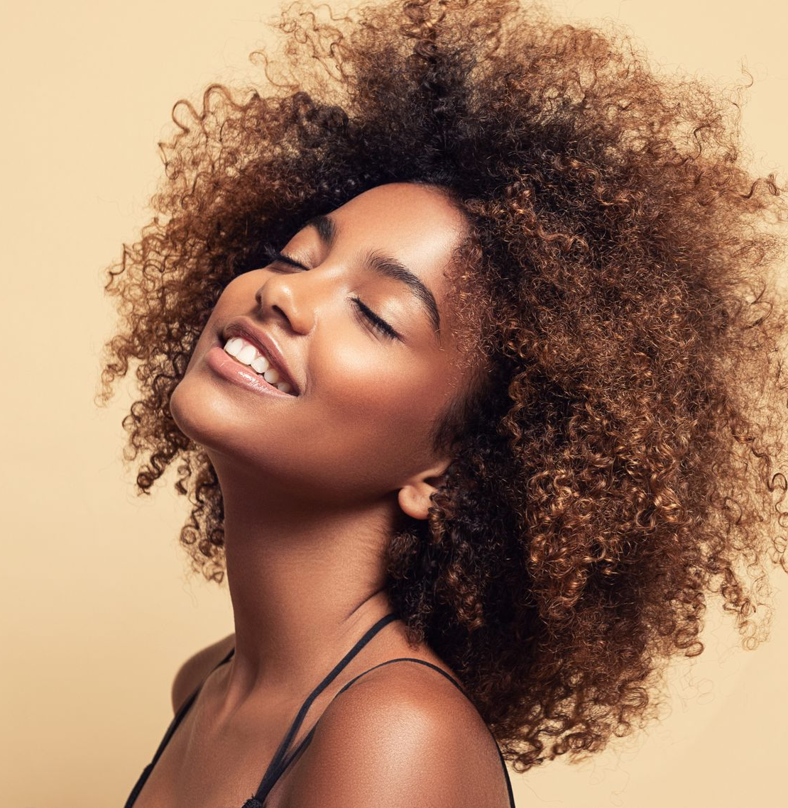 Wooden tray with skincare products, incense burner, and folded towels on a white surface.