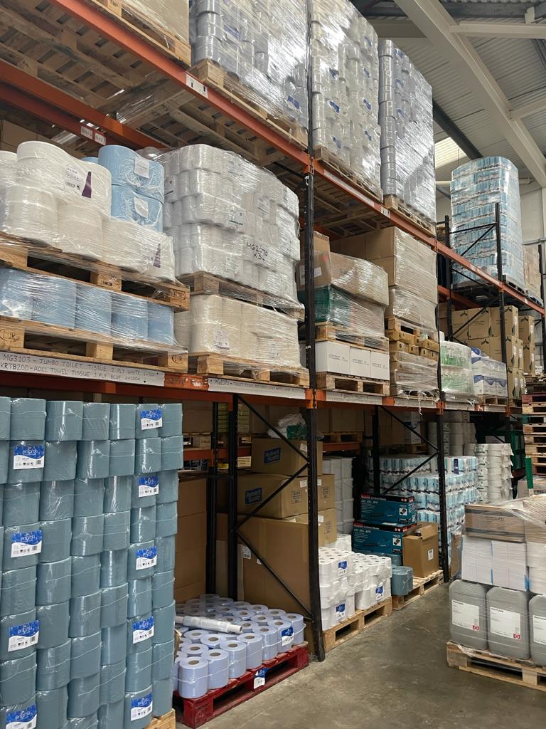 Warehouse shelves stacked with pallets of packaged goods.
