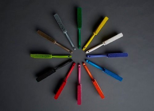 Assortment of vibrantly colored brushes arranged in a circle on a gray background.