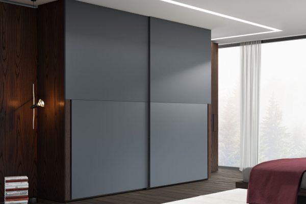 Una camera da letto con un grande armadio scorrevole e un letto.