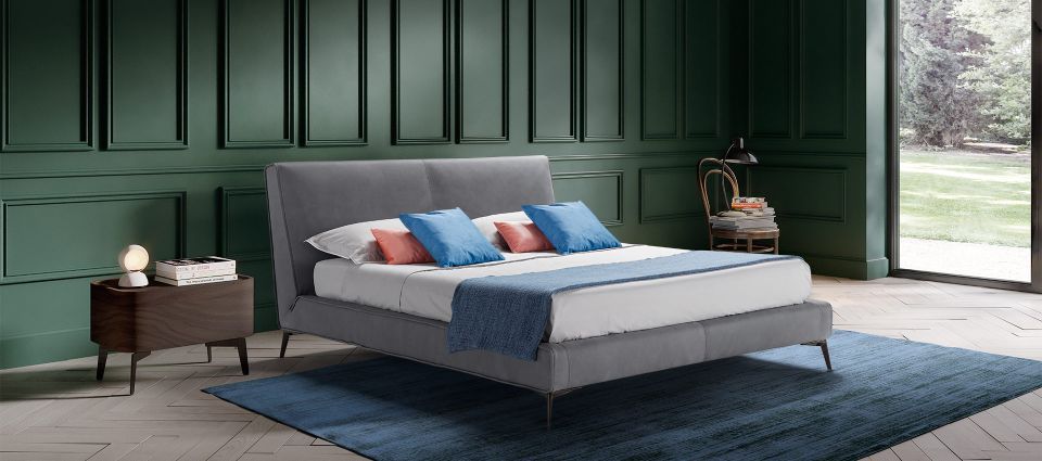 letto matrimoniale grigio con cuscini celesti e rosa