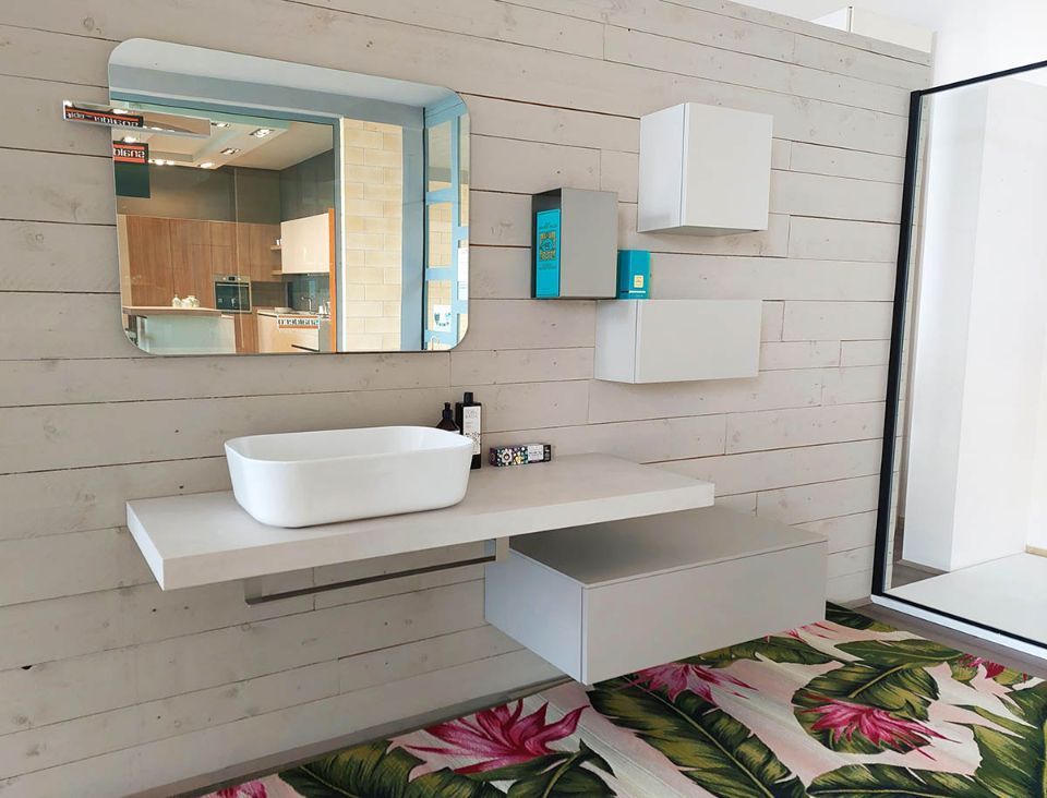 bagno con pensili bianchi e pavimento a fiori