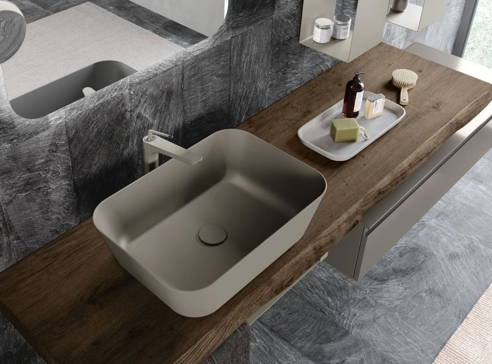 bagno con piano in legno e lavabo grigio di design