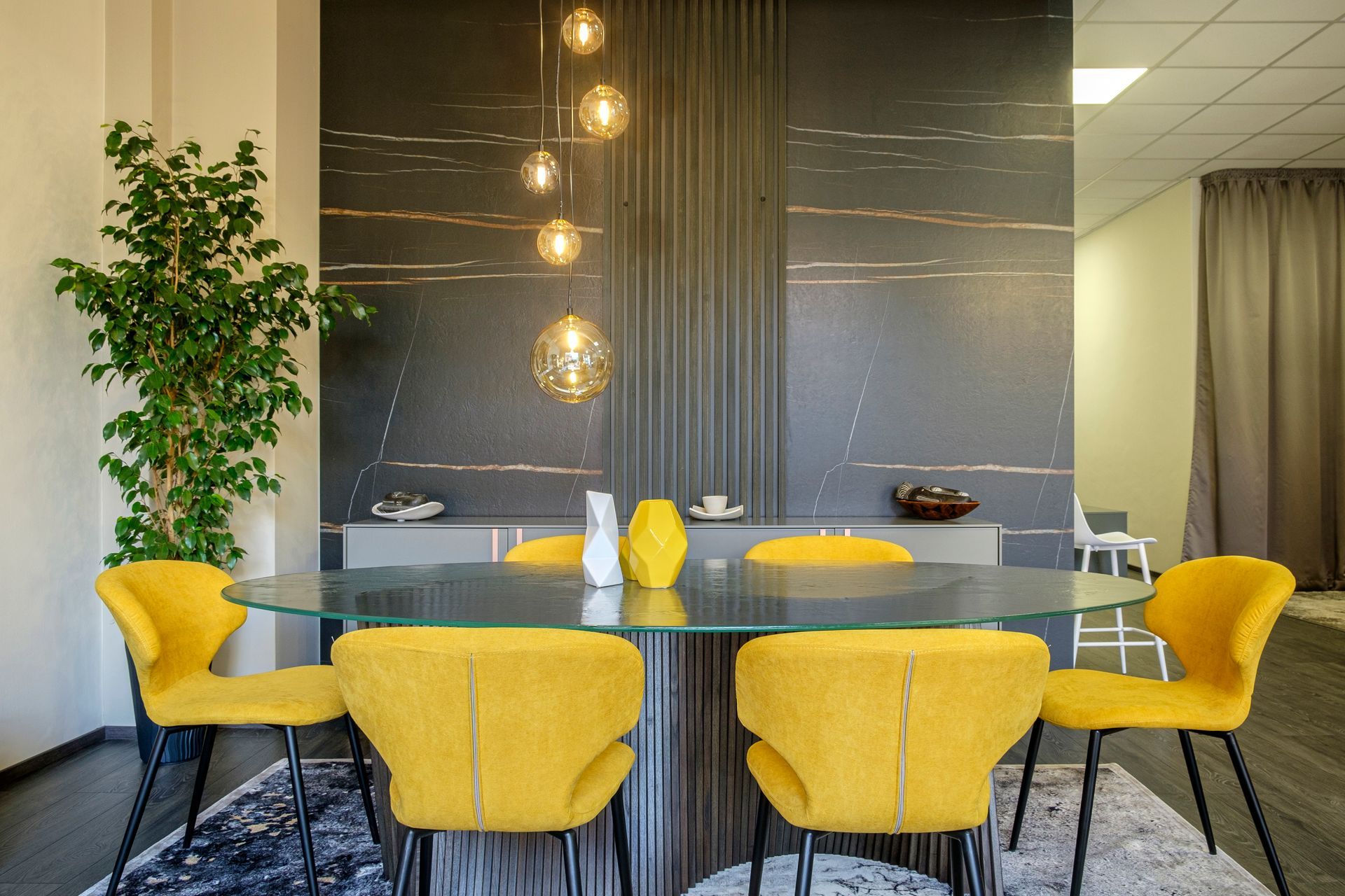 Una sala da pranzo con sedie gialle e un tavolo di vetro.