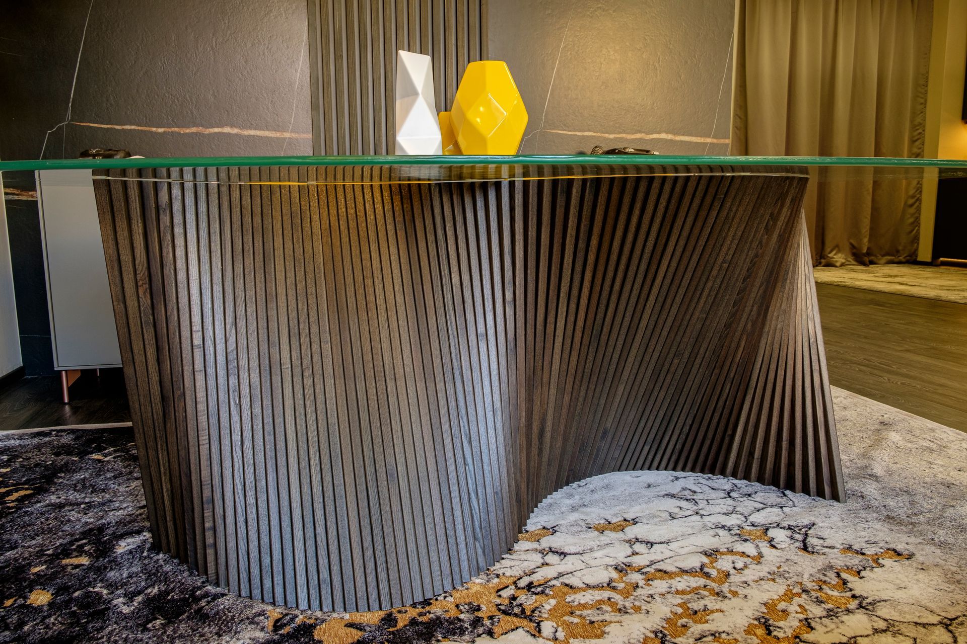 Un tavolo con un piano di vetro è appoggiato su un tappeto in una stanza.