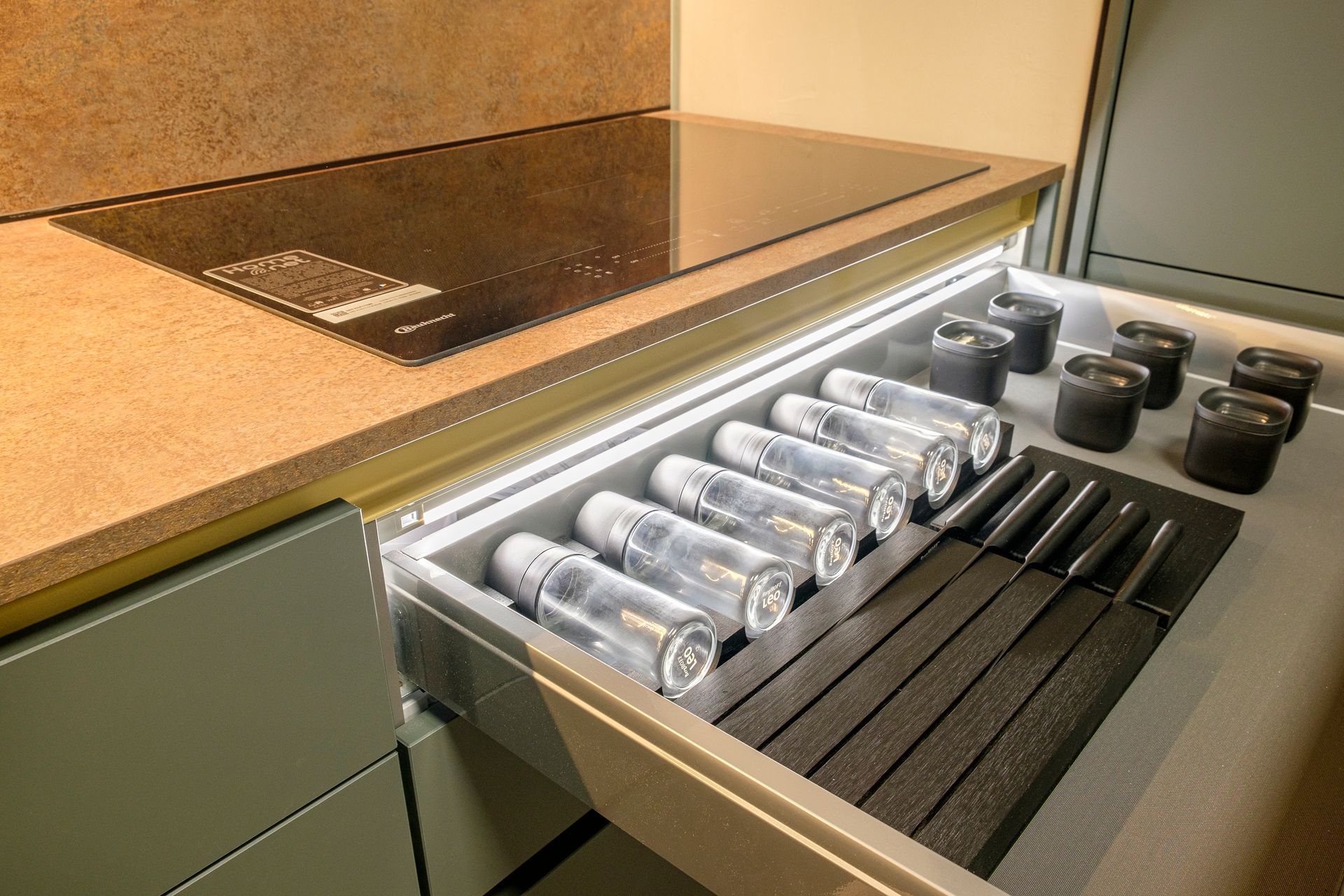 Una cucina con un cassetto pieno di bottiglie e barattoli.