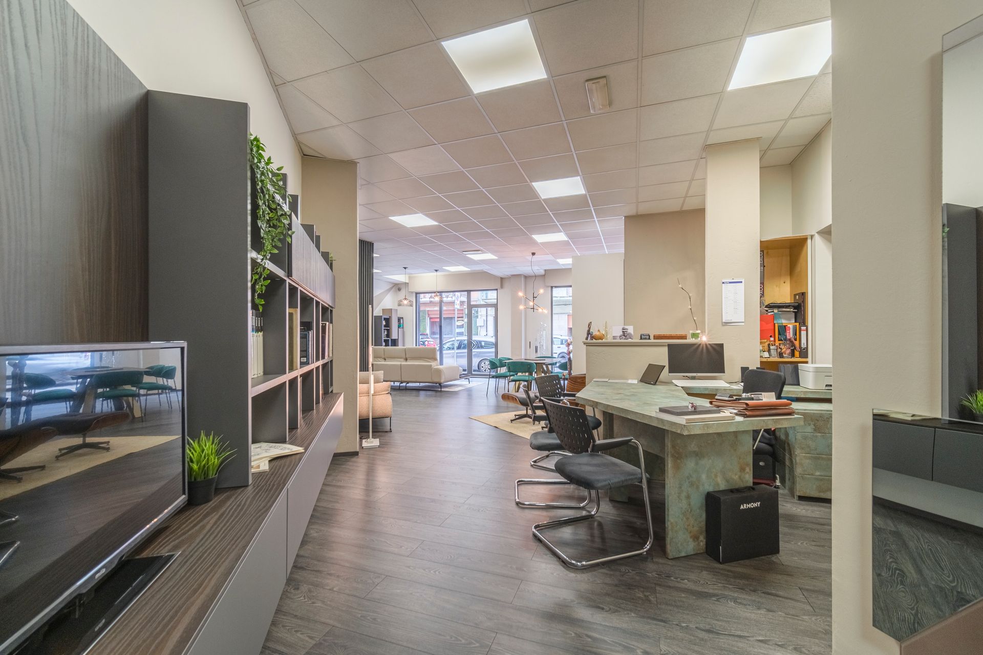 Una grande stanza con molti mobili e una televisione alla parete.