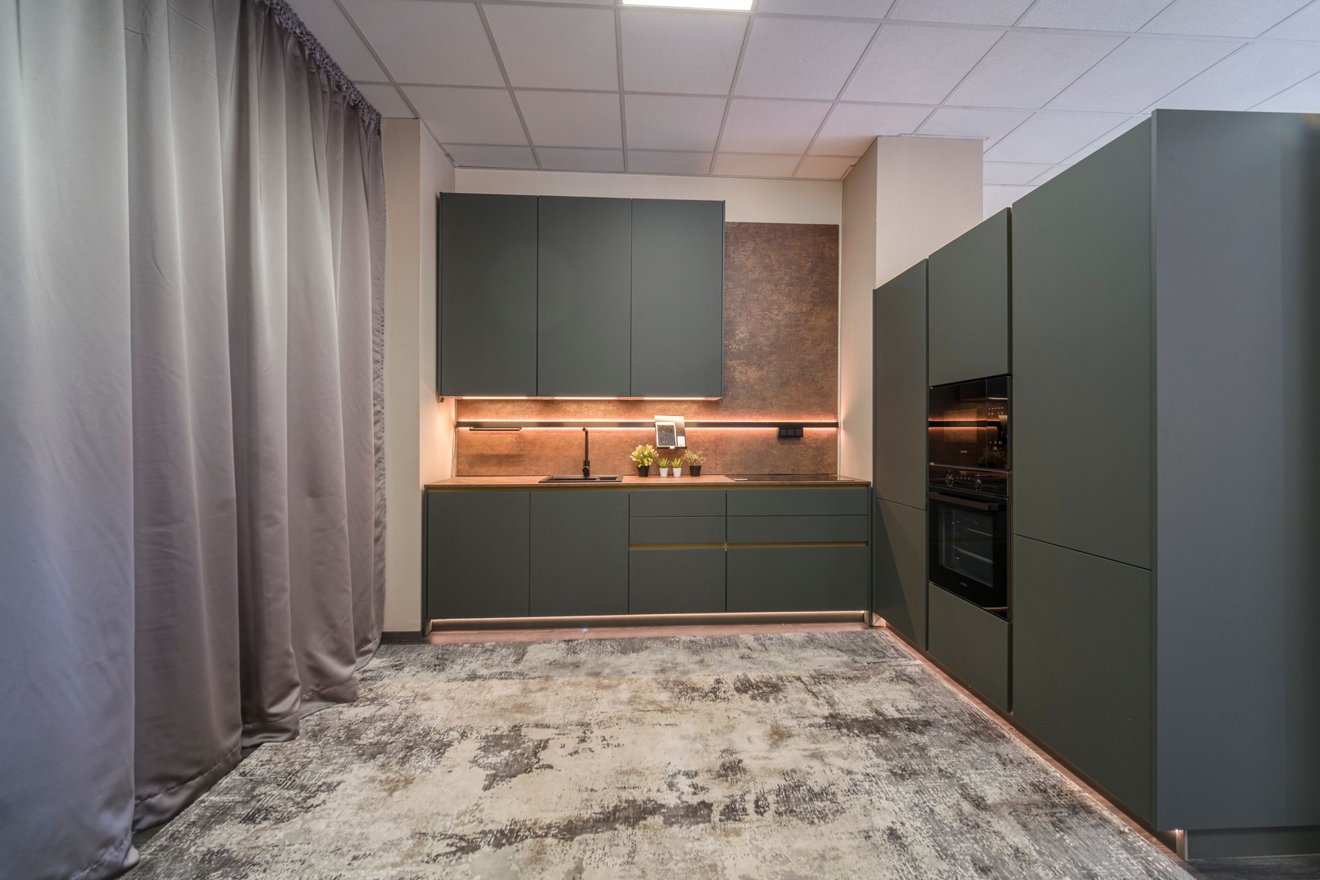 Una cucina con mobili verdi e un tappeto sul pavimento.