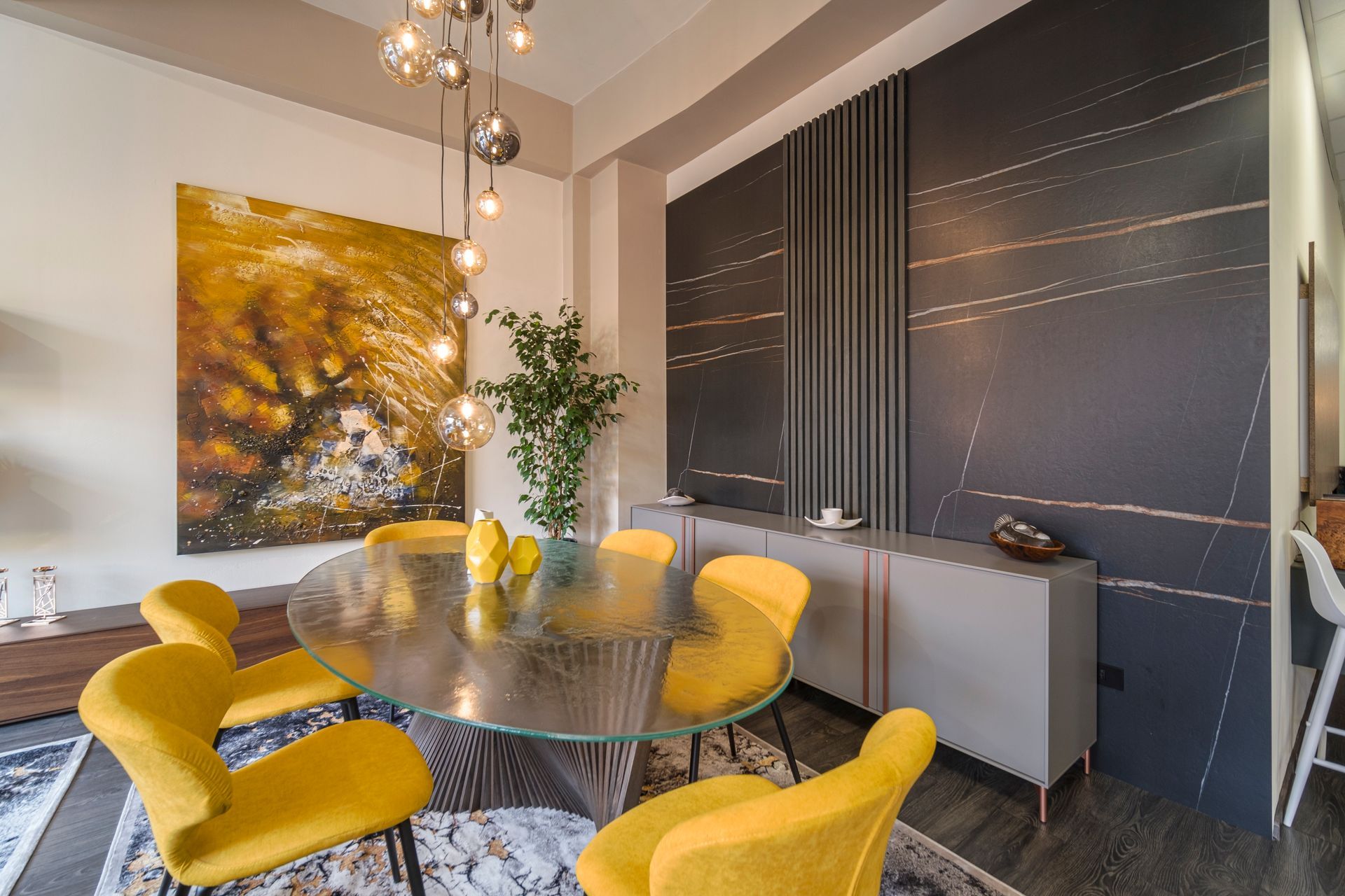 Una sala da pranzo con un tavolo di vetro e sedie gialle.