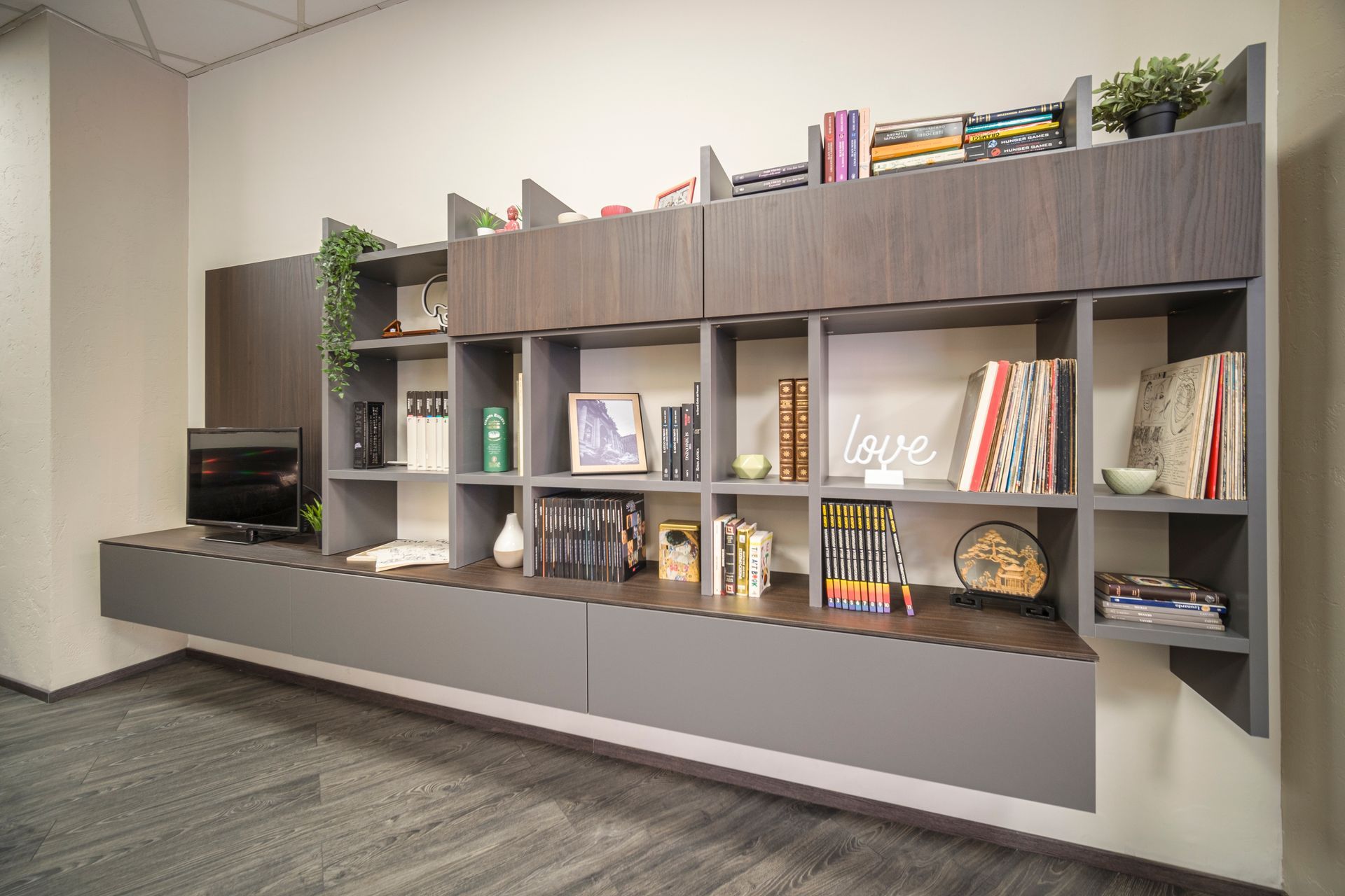 Una stanza con uno scaffale pieno di libri e una scrivania.