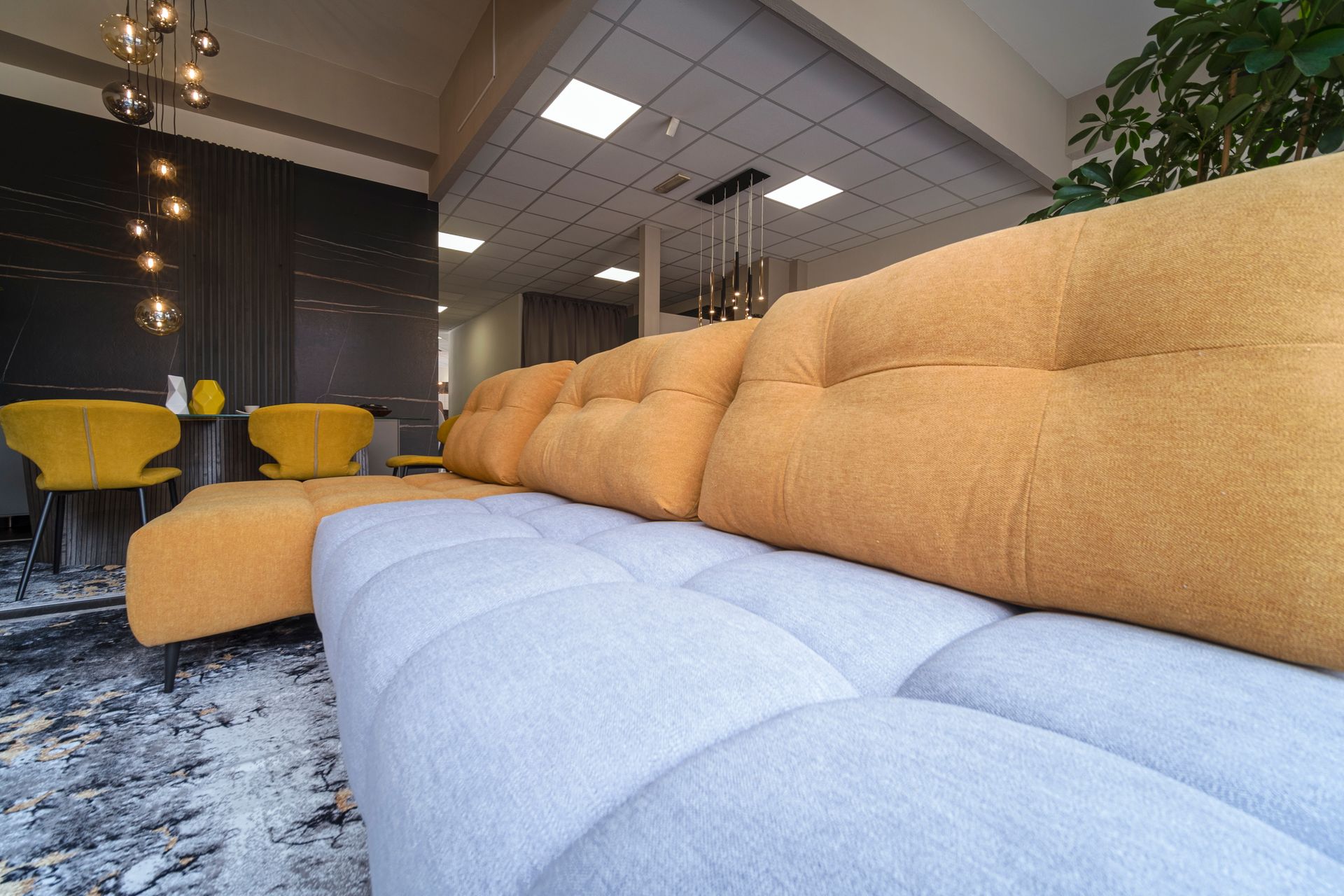 Un divano componibile giallo e grigio è posizionato nel soggiorno.